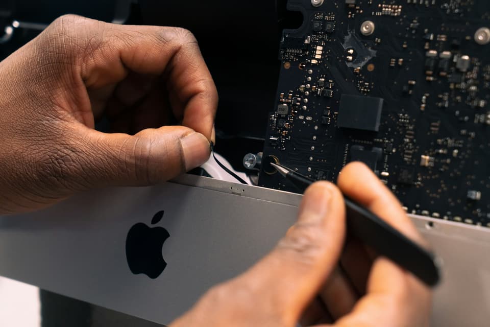 Apertura di un computer Apple con gli attrezzi di precisione
