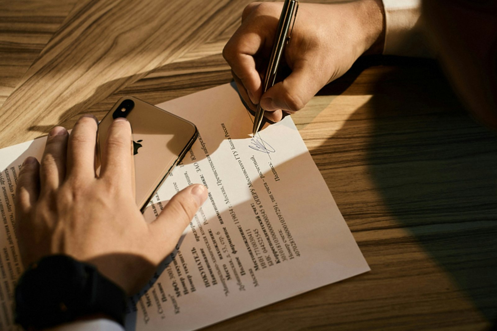 Firma di un contratto su una scrivania in legno