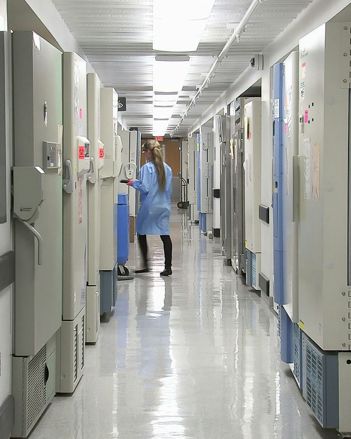Corridoio luminoso di un reparto ospedaliero con un operatore in fondo