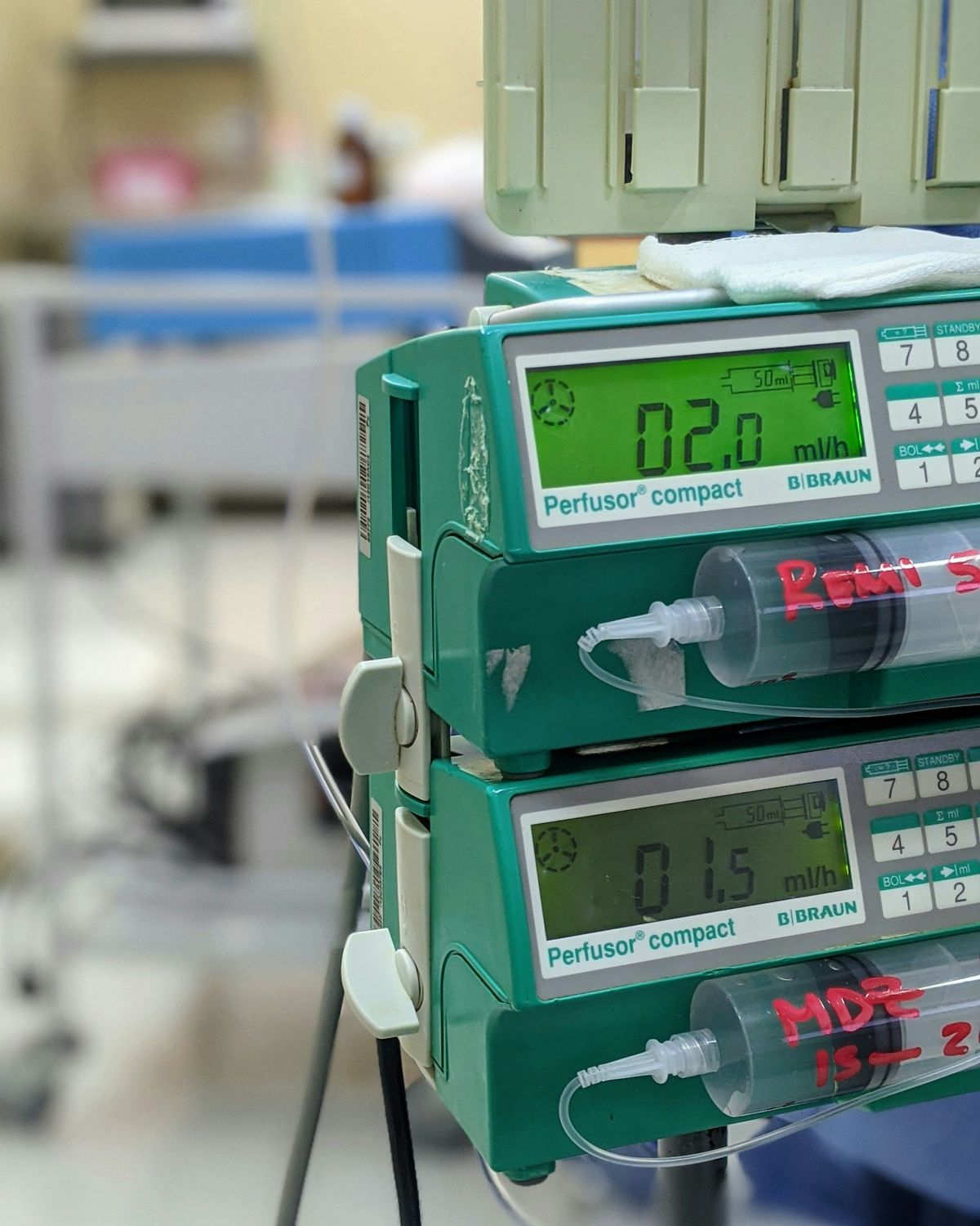 Pompe infusionali montate su un'asta accanto a un letto di degenza