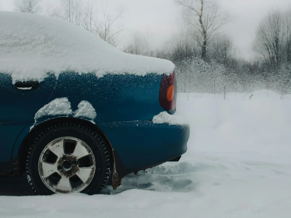 Auto blu coperta di neve, ruota posteriore affondata