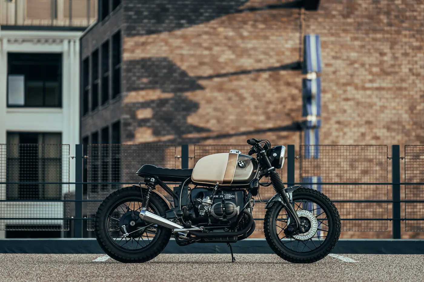 Café racer con motore boxer davanti a un muro di mattoni