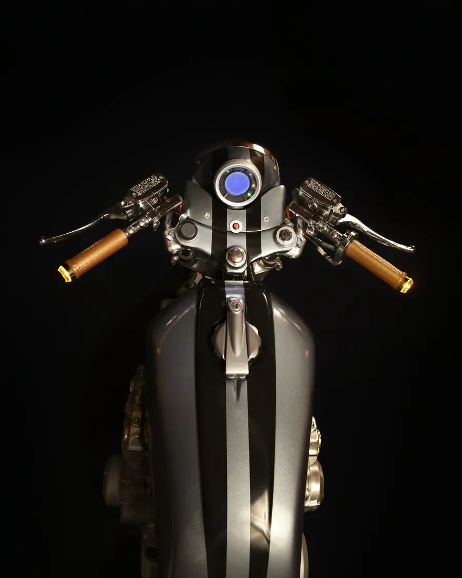 Serbatoio e manubrio di una moto visti dall'alto su fondo nero
