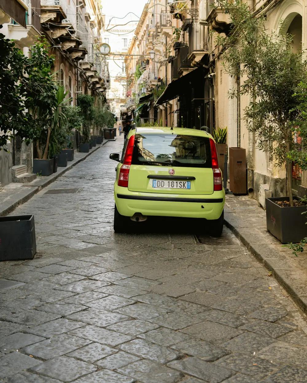 Utilitaria verde lime in una via stretta del centro storico