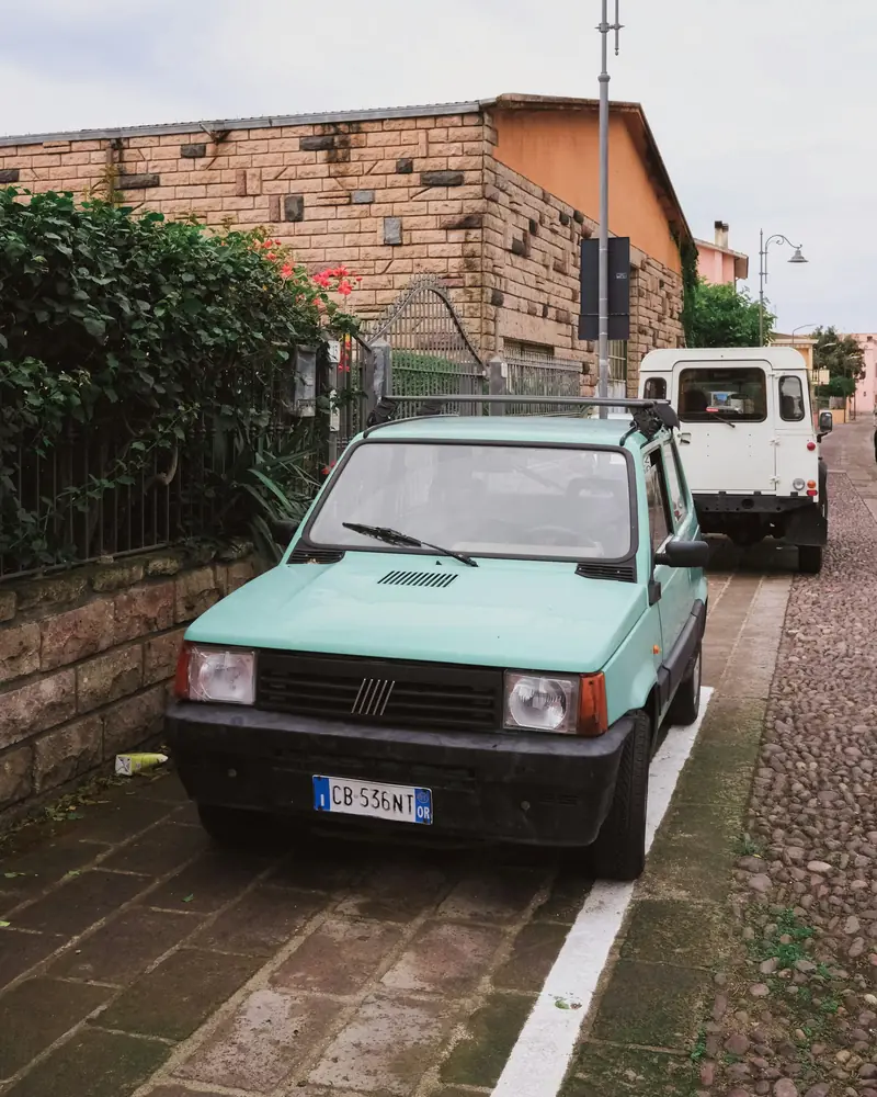 Utilitaria verde menta su una strada di paese