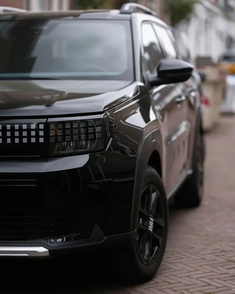 SUV nero parcheggiato su una strada lastricata