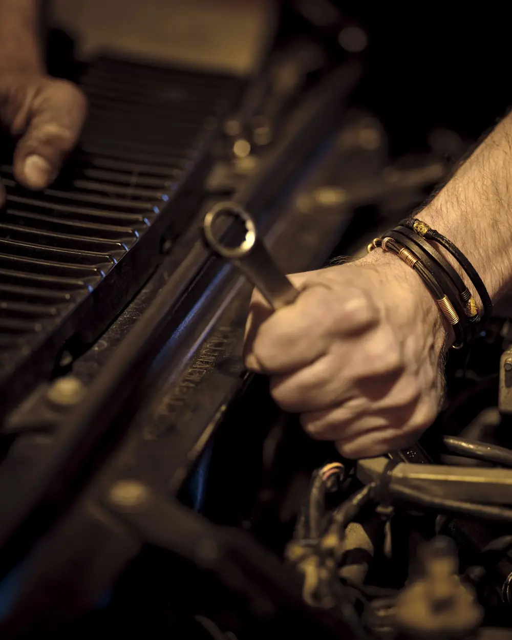 Mani con la chiave inglese sul motore