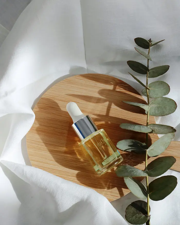 Flacone di olio da massaggio con rametti di eucalipto