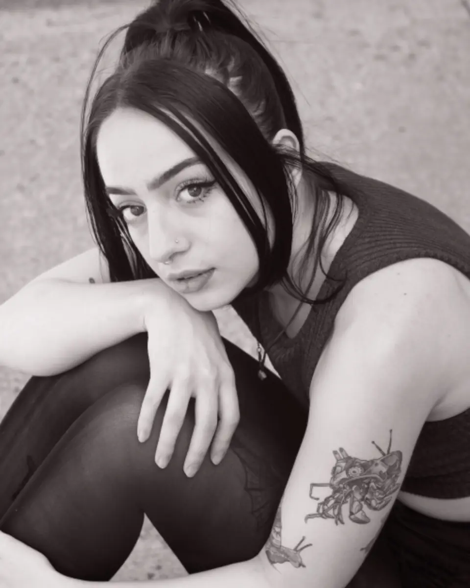 Ragazza con un tatuaggio floreale sul braccio, in bianco e nero