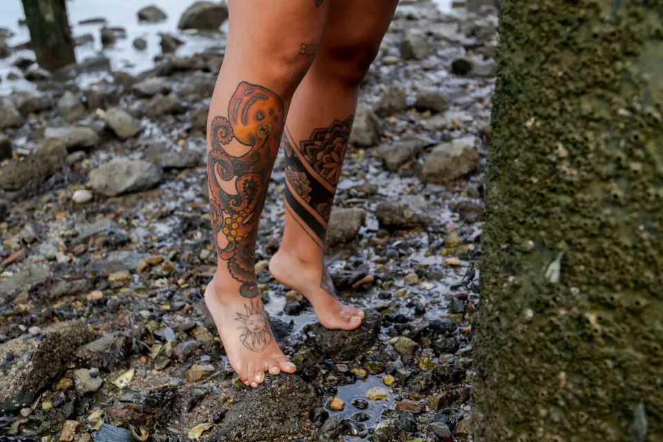 Gambe tatuate a colori sui sassi