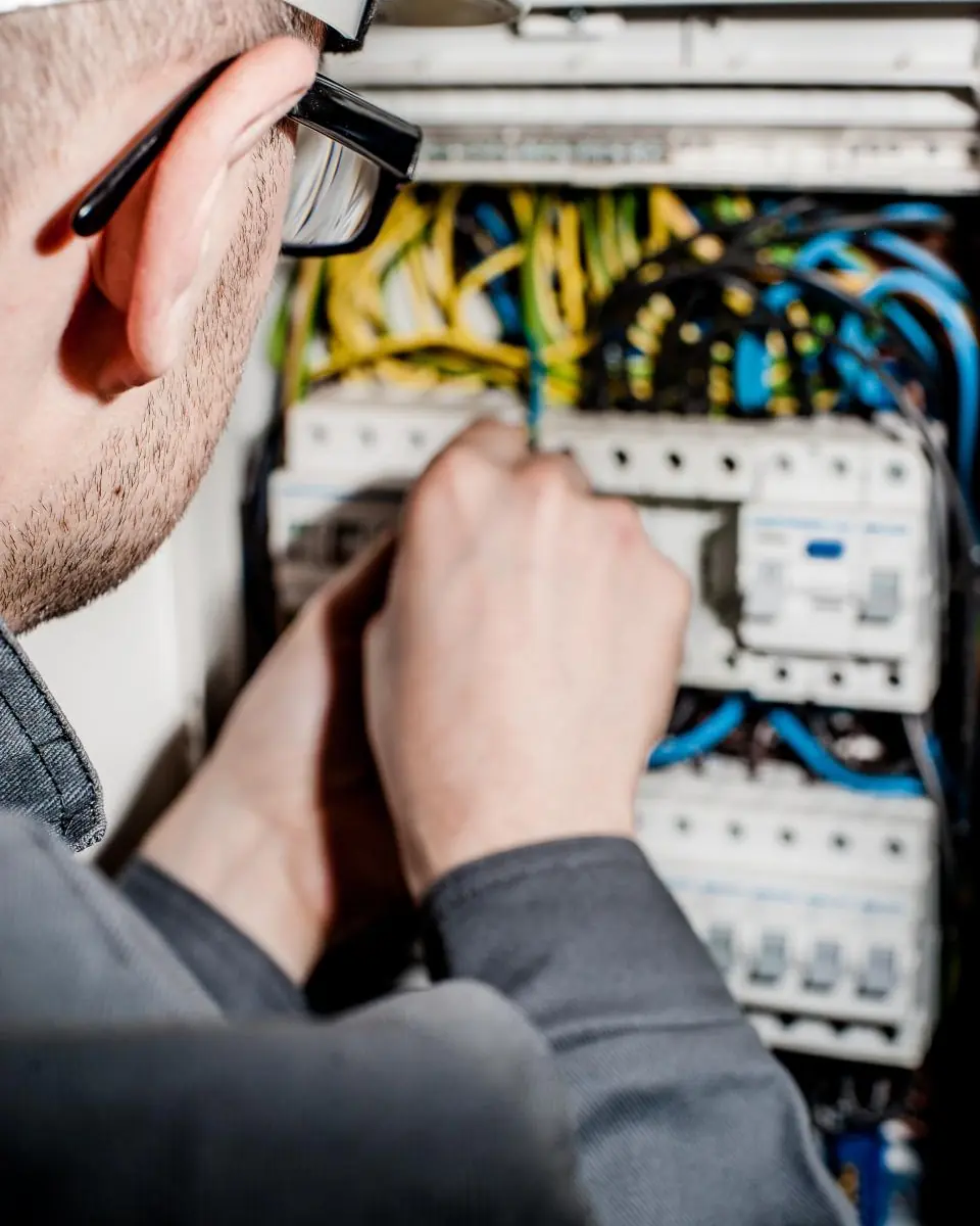Elettricista al lavoro dentro un quadro elettrico