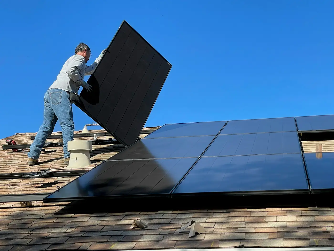 Installatore che monta un pannello fotovoltaico sul tetto
