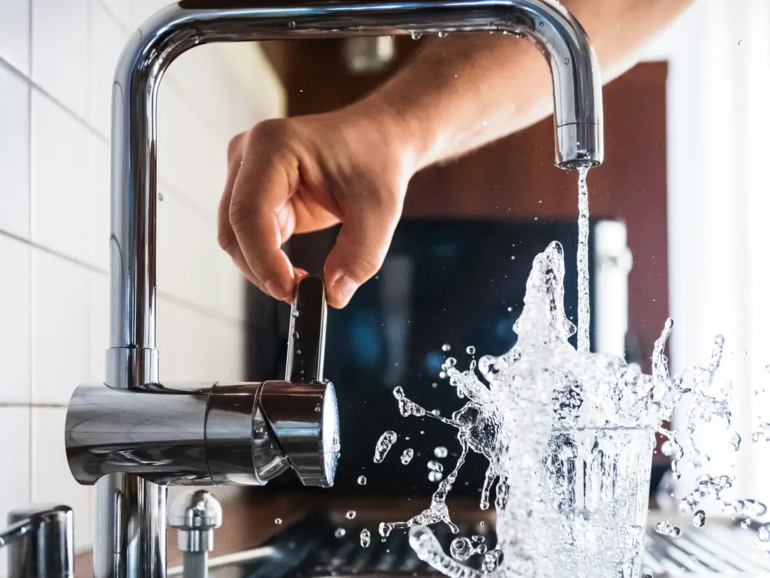 Acqua che schizza da un rubinetto della cucina