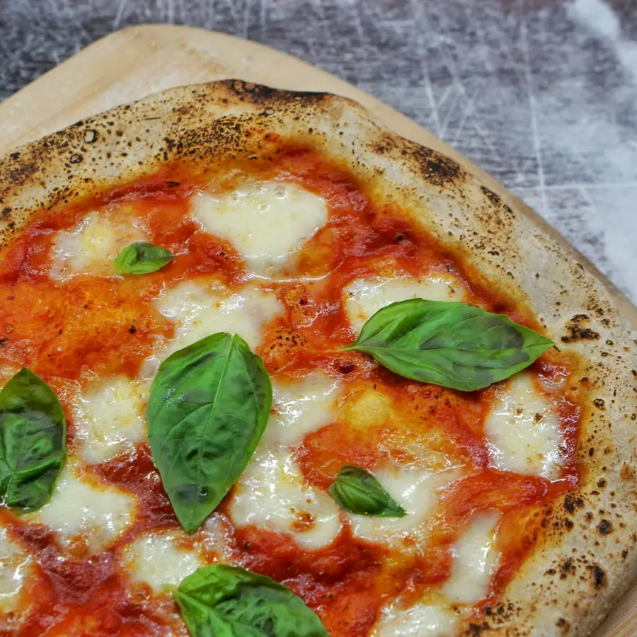 Pizza con mozzarella di bufala e foglie di basilico