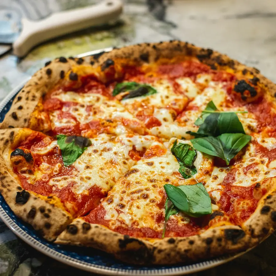 Pizza margherita napoletana con basilico e cornicione alto
