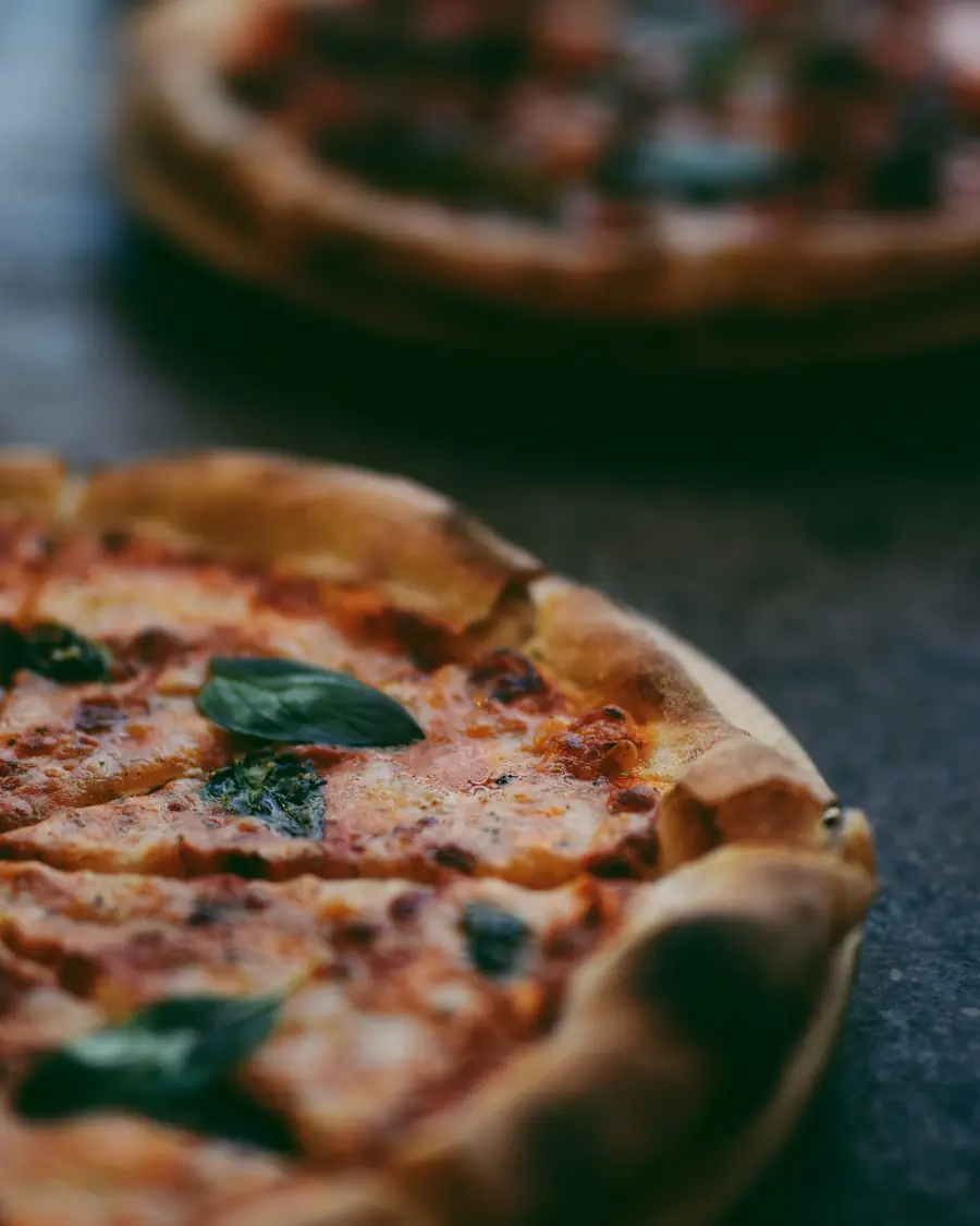 Pizza appena uscita dal forno su un tavolo scuro
