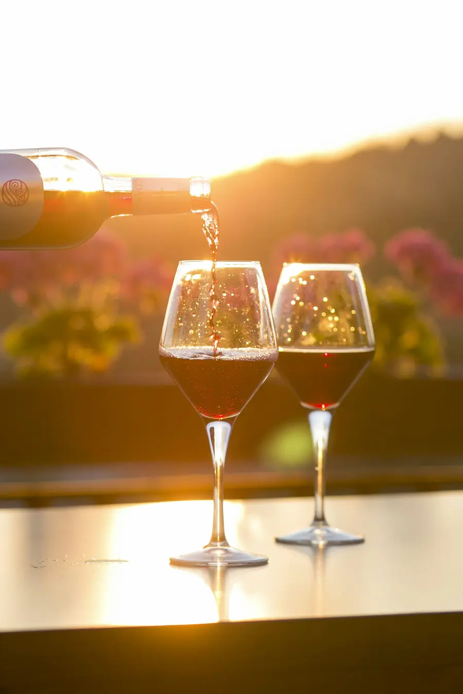 Vino versato in due calici al tramonto