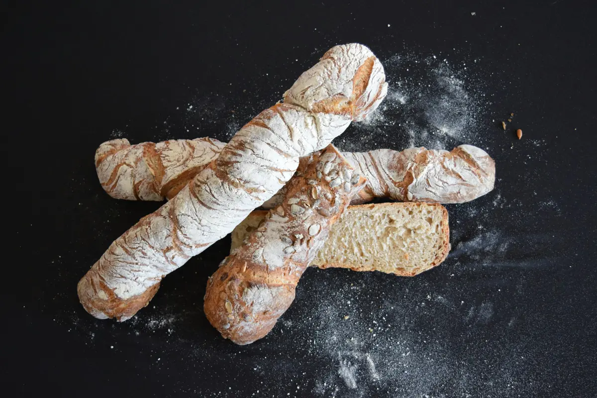 Filoni di pane infarinati su fondo scuro
