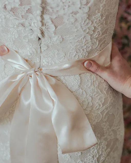 Fiocco in raso sulla schiena di un abito da sposa in pizzo