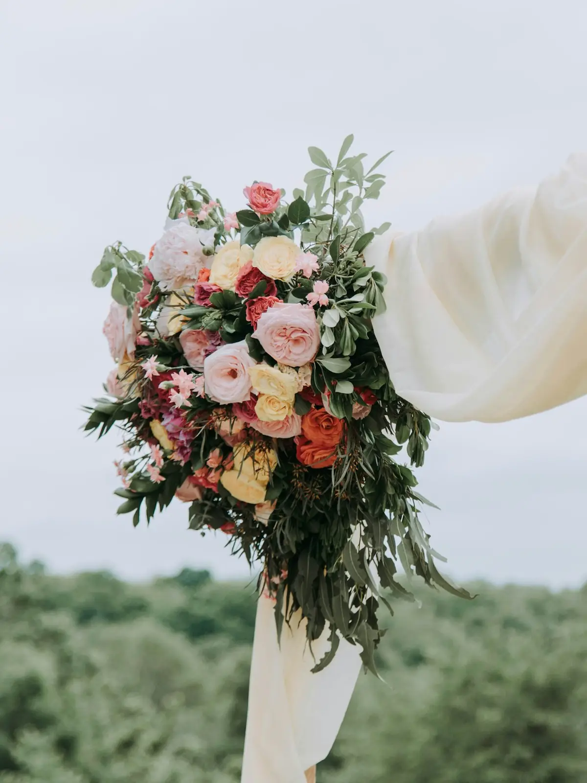 Arco di legno con drappo e fiori per la cerimonia in giardino