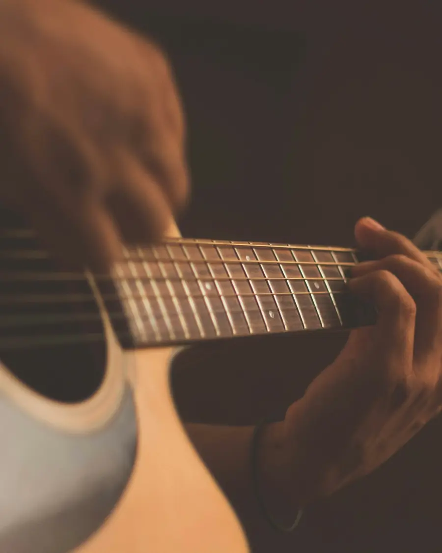 Mano che suona una chitarra acustica