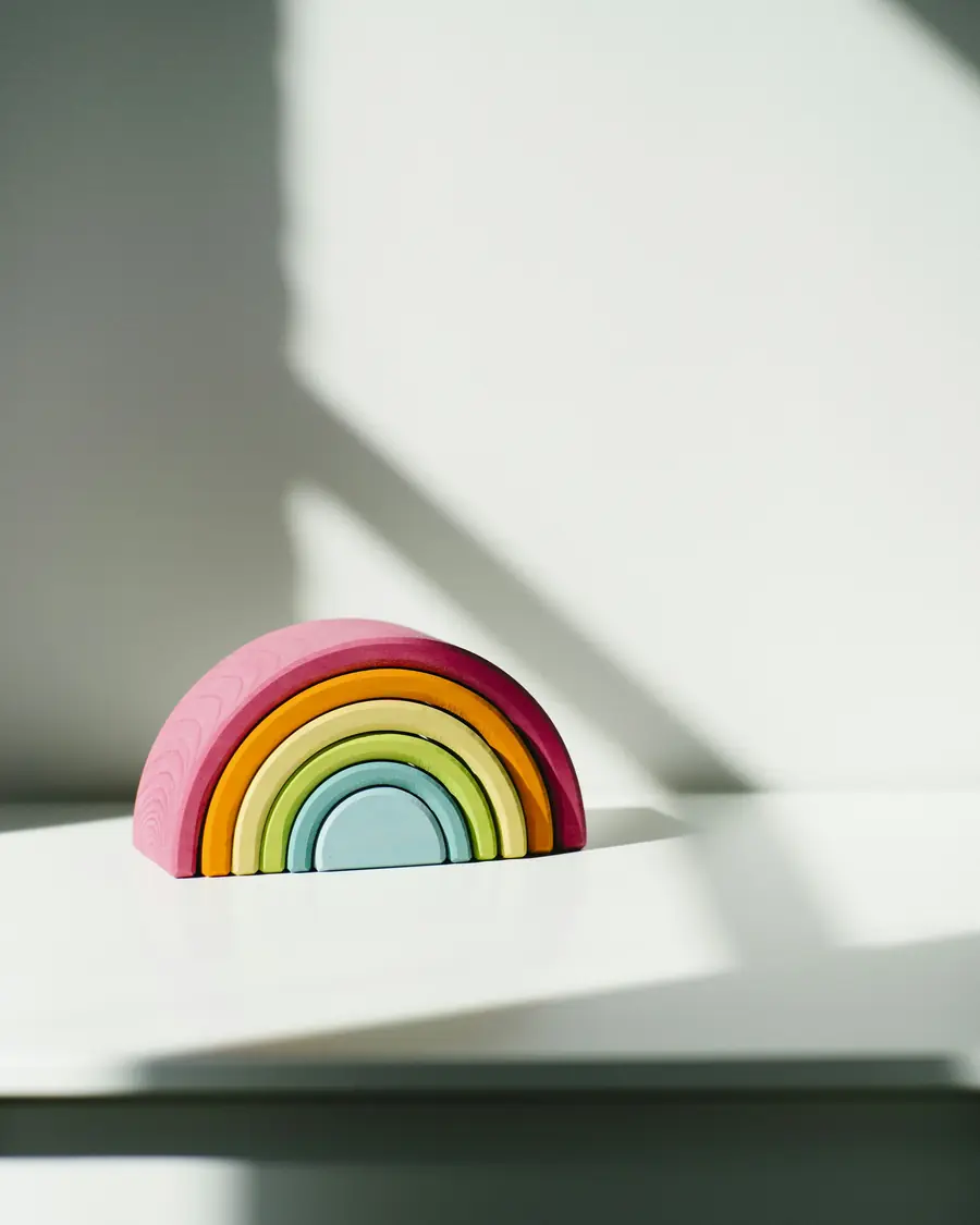 Arcobaleno di legno a incastro su un ripiano bianco