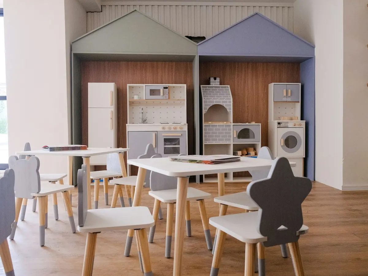 Sala con tavolini, sedie a forma di stella e cucina giocattolo
