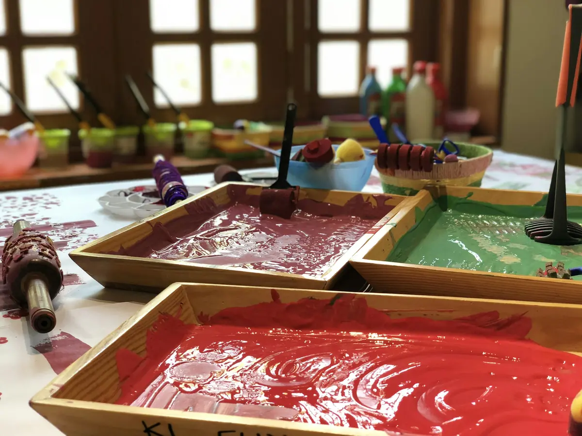 Vassoi di legno pieni di tempera rossa e verde sul tavolo del laboratorio