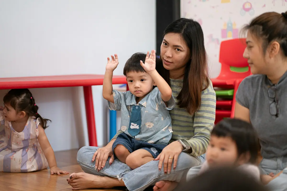 Due educatrici sedute a terra con i bambini durante il cerchio del mattino
