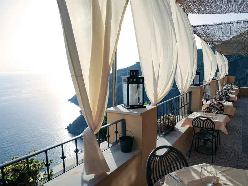 Terrazza con tende bianche affacciata sul mare