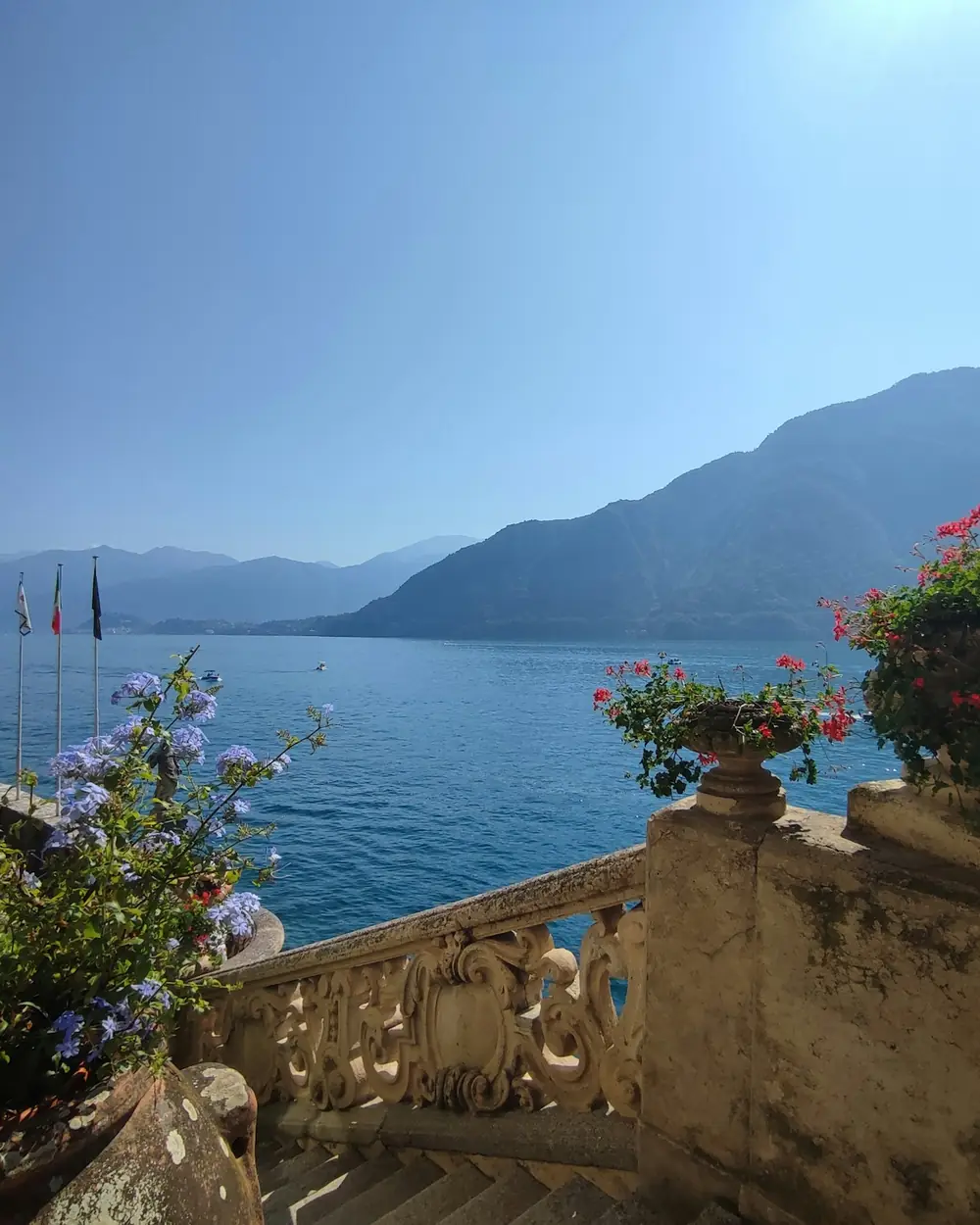 Balcone in pietra con fiori e vista sul lago