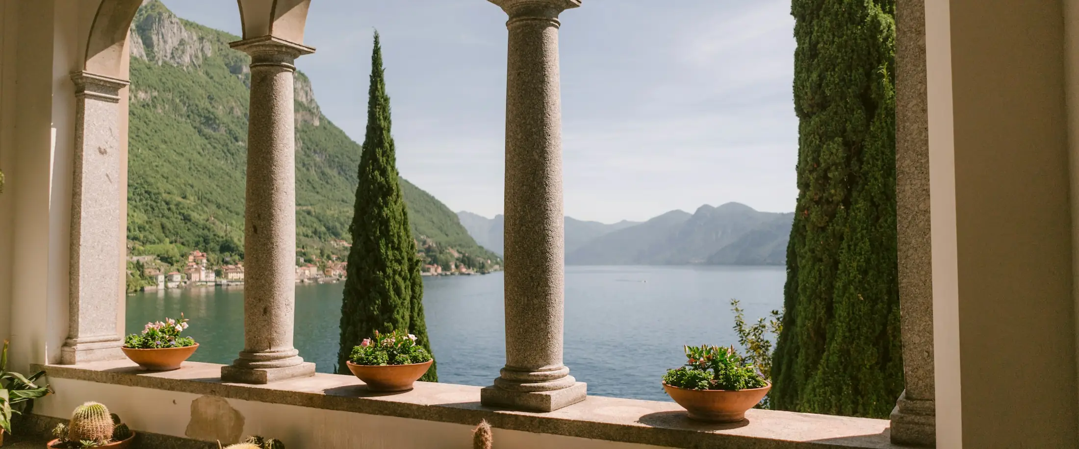 Loggia ad archi con colonne e piante affacciata sul lago