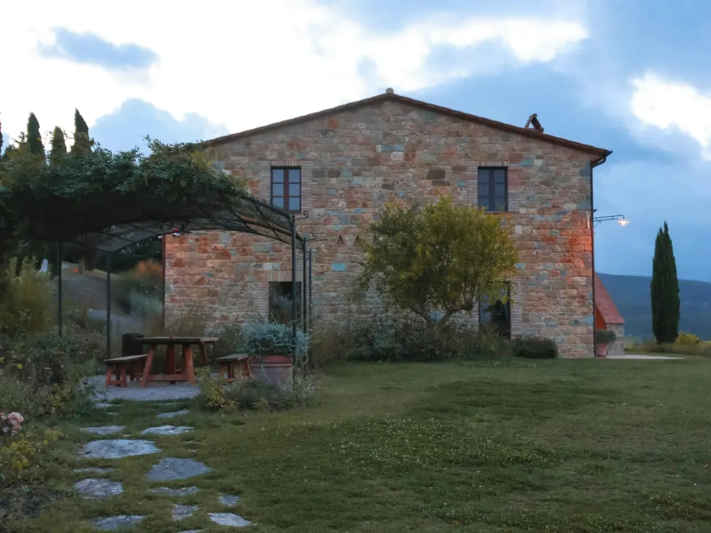 Casale in pietra con pergolato, vialetto e cipressi