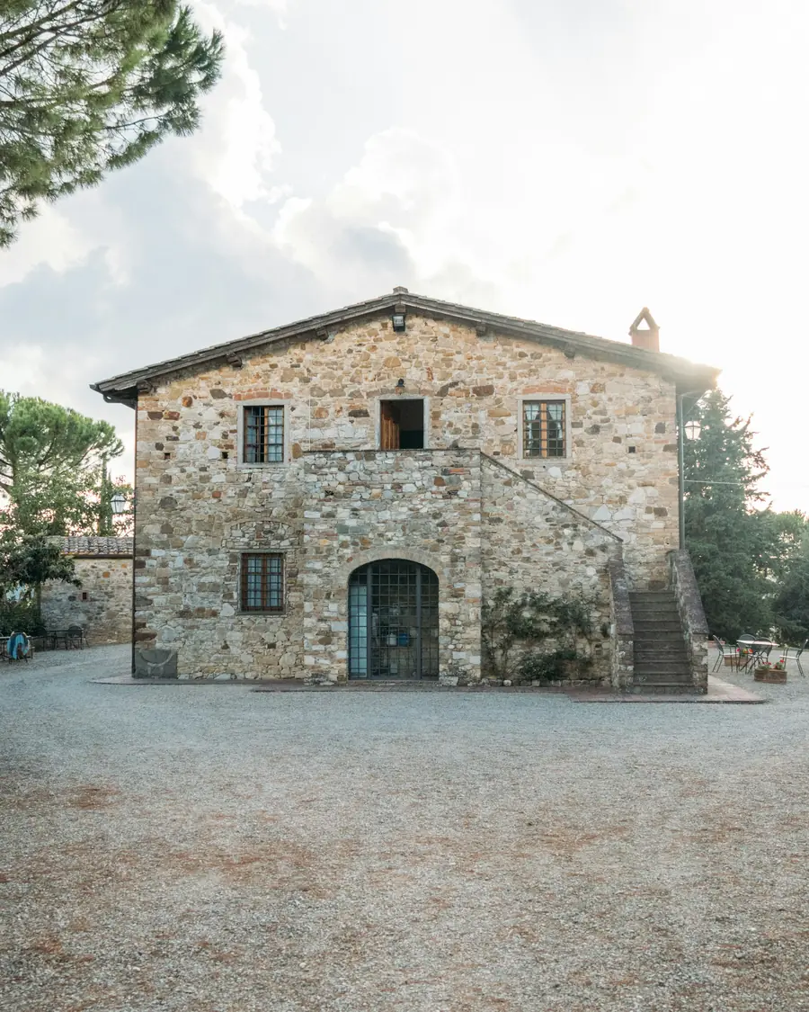 Casa in pietra con porta ad arco e scala esterna