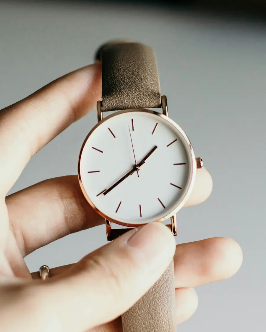 Orologio con cinturino in pelle tenuto in mano