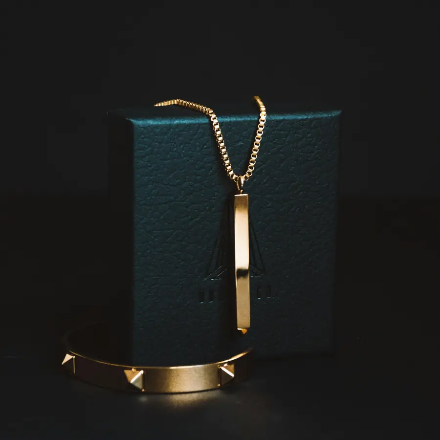 Collana con barretta d'oro su scatola verde scuro