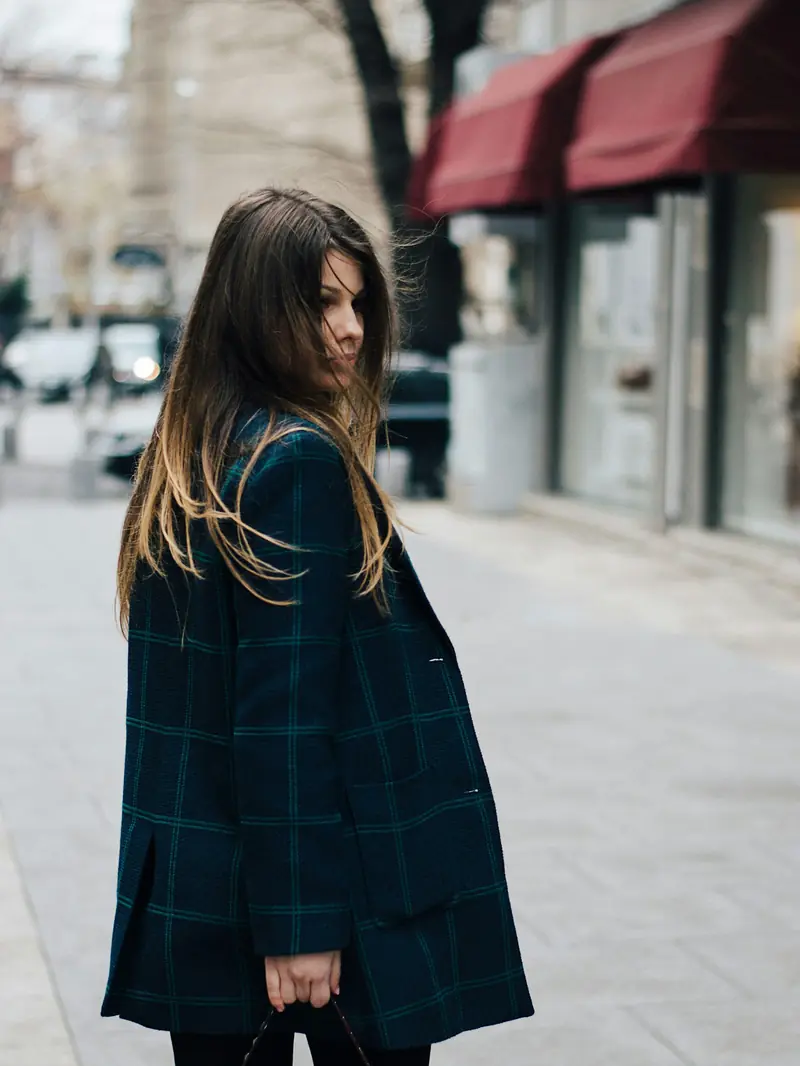 Cappotto a quadri e borsa bordeaux in strada