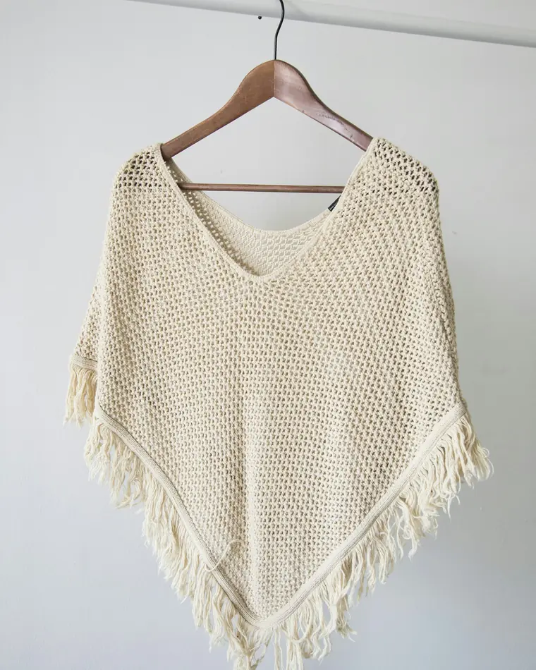 Poncho in maglia color panna con frange