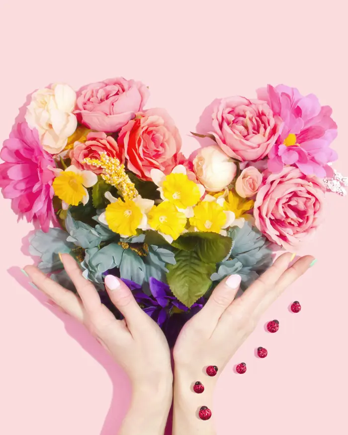 Cuore di fiori tenuto tra le mani