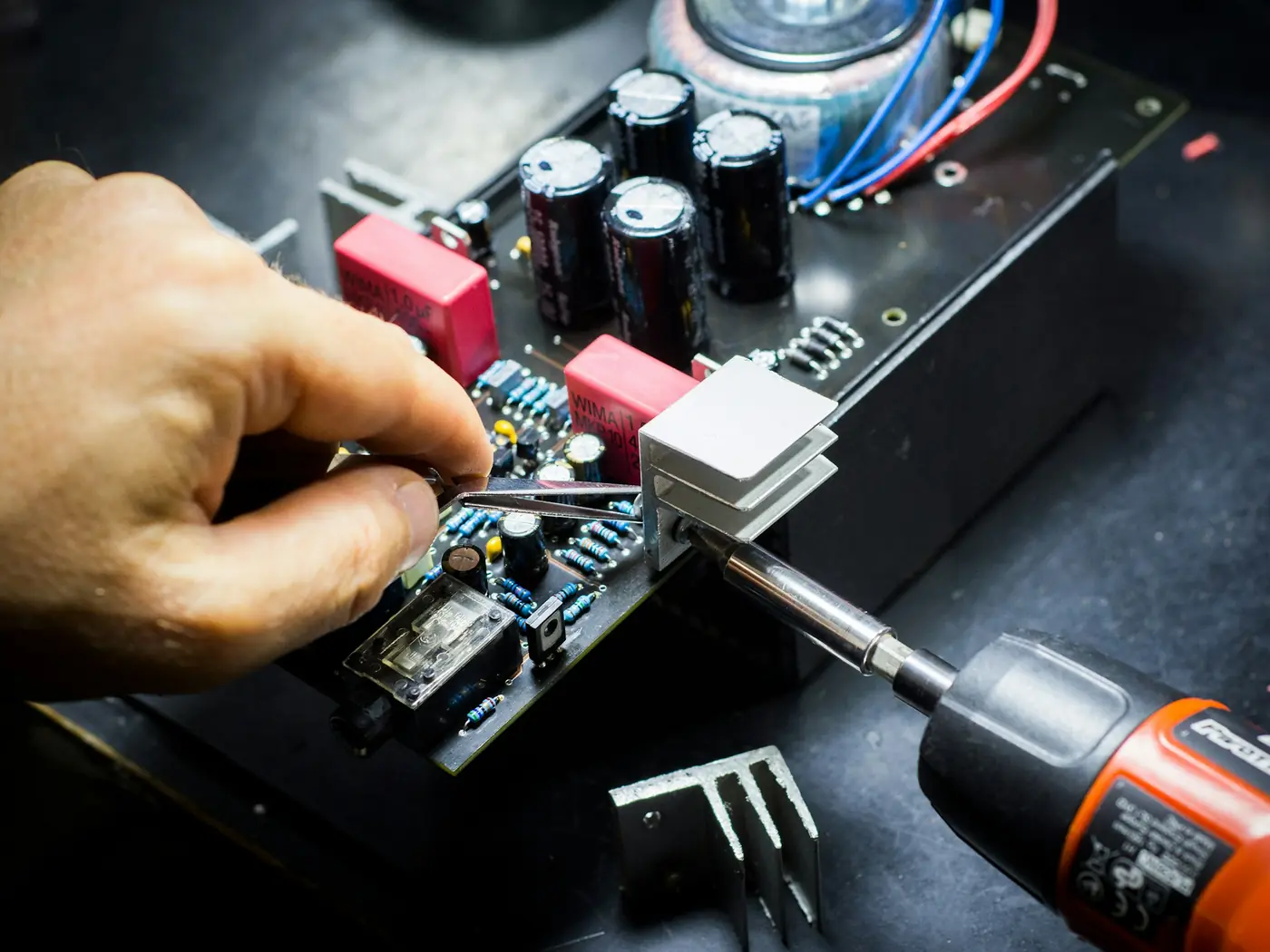 Tecnico che ripara una scheda elettronica con il cacciavite