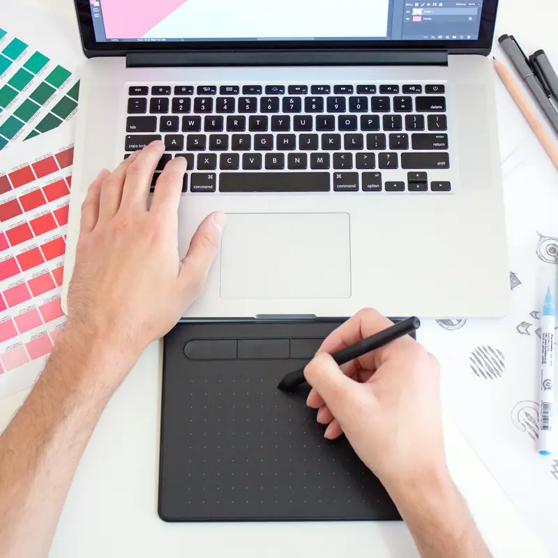 Grafico al lavoro con tavoletta e campioni di colore