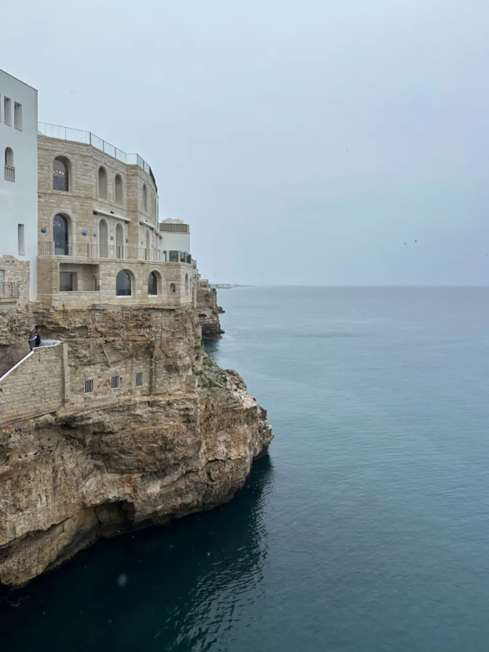 Case bianche sulla scogliera di Polignano a Mare sopra il mare calmo