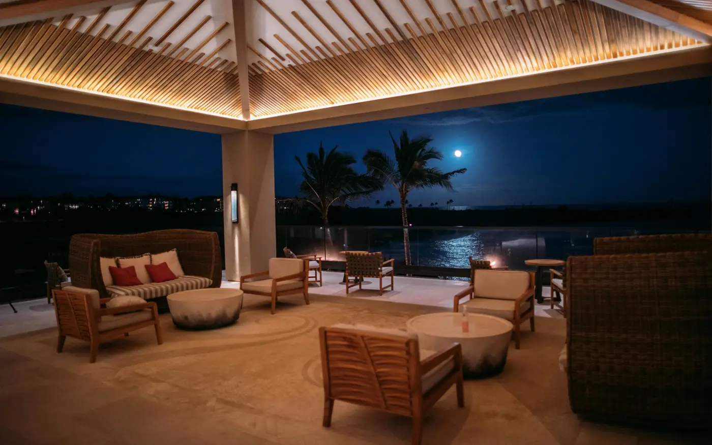 Terrazza coperta con divani e vista sul mare di notte