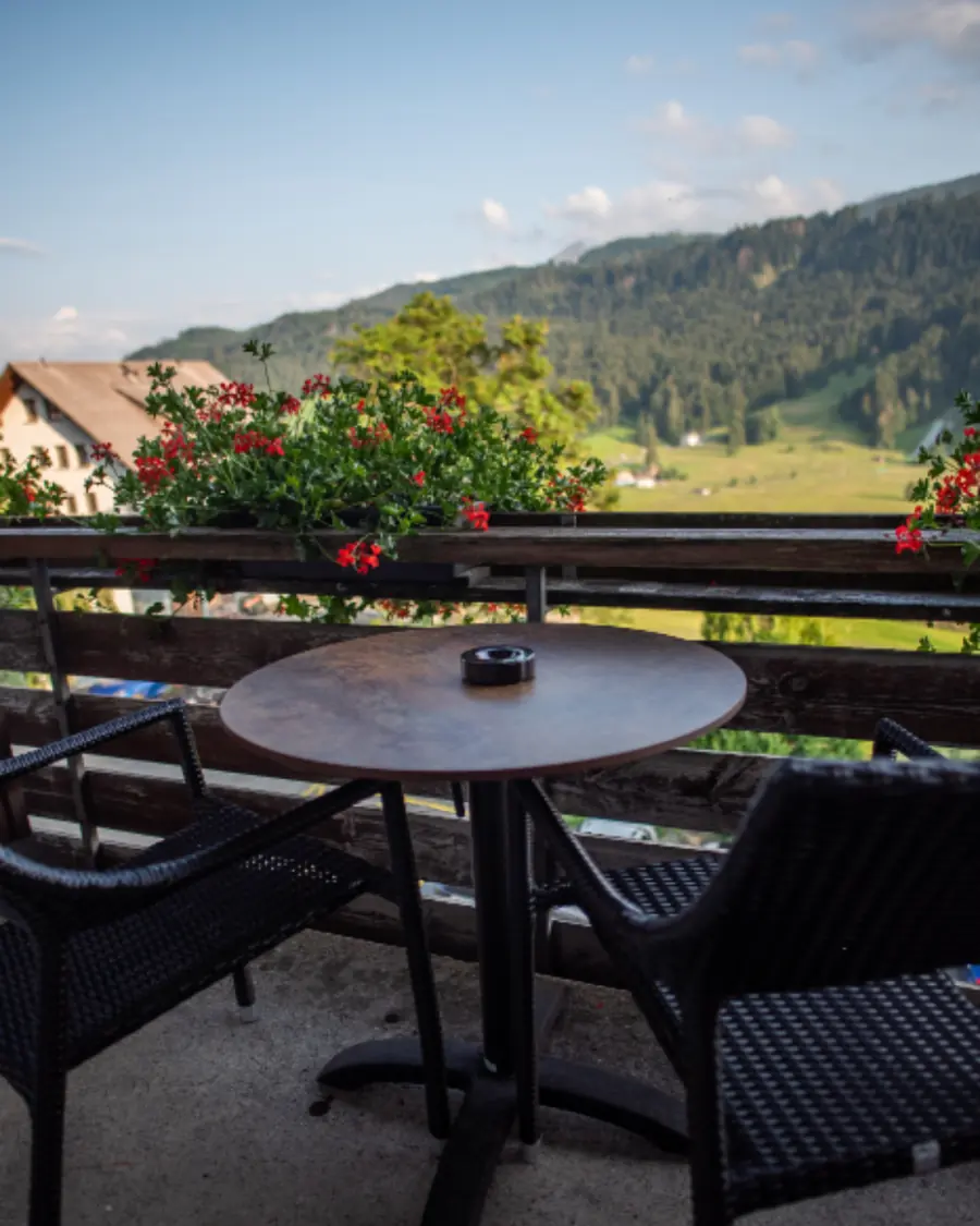 Tavolino sulla loggia con i gerani e la vista sulle colline