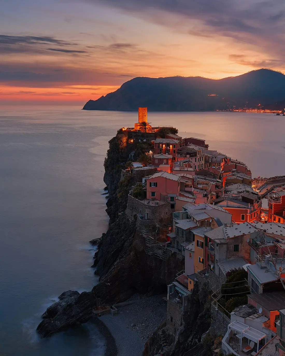 Vernazza al tramonto con le case sul promontorio e il mare