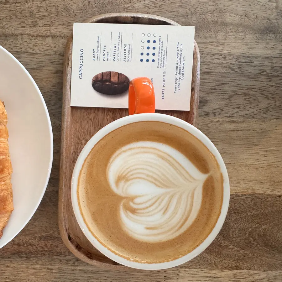 Cappuccino e cornetto sul vassoio del bar