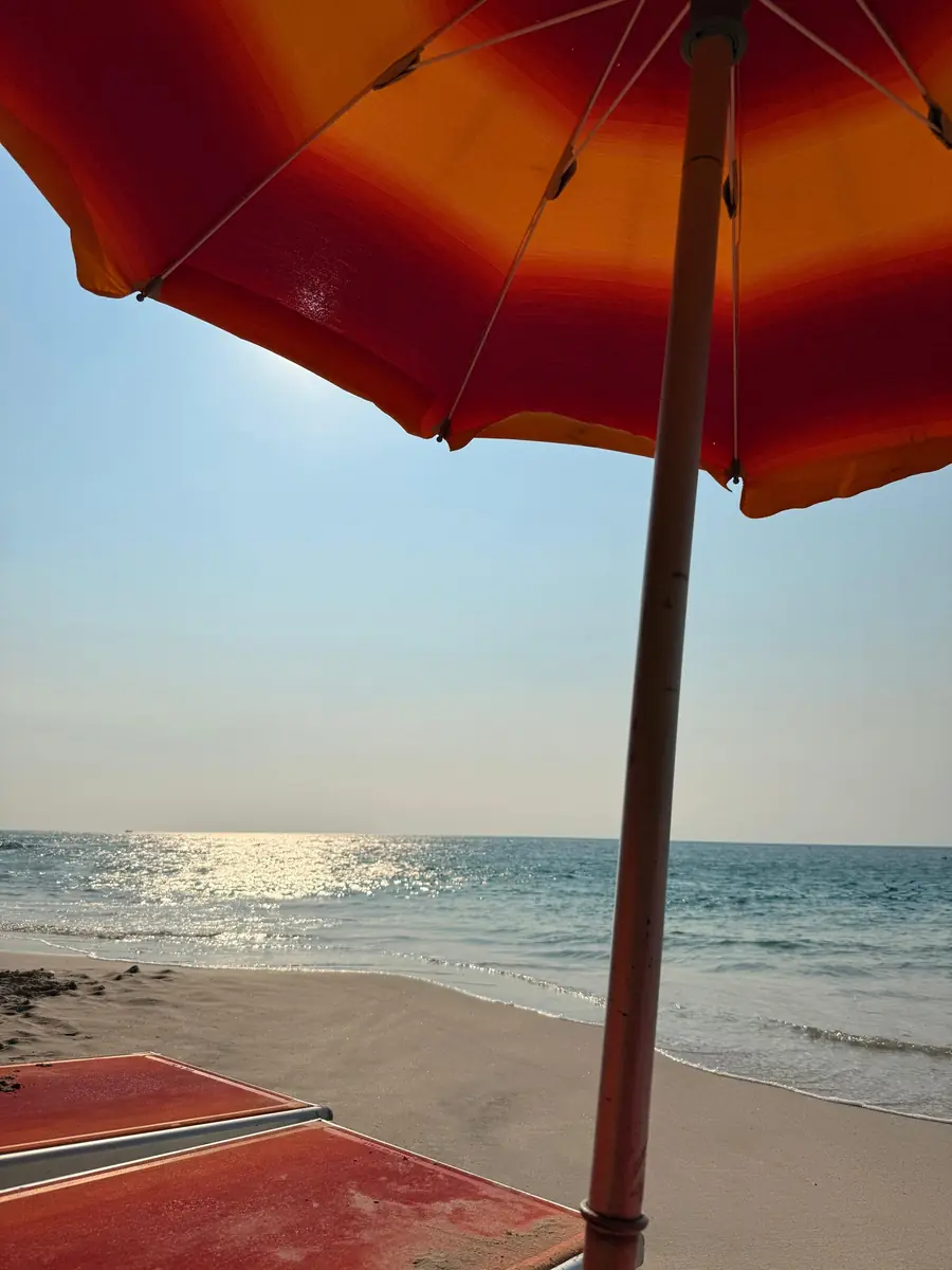 Ombrellone arancione sulla spiaggia davanti al mare