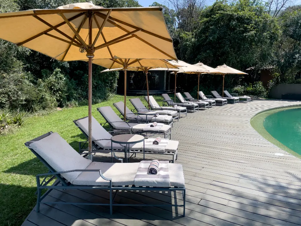 Piscina con lettini e ombrelloni tra il verde