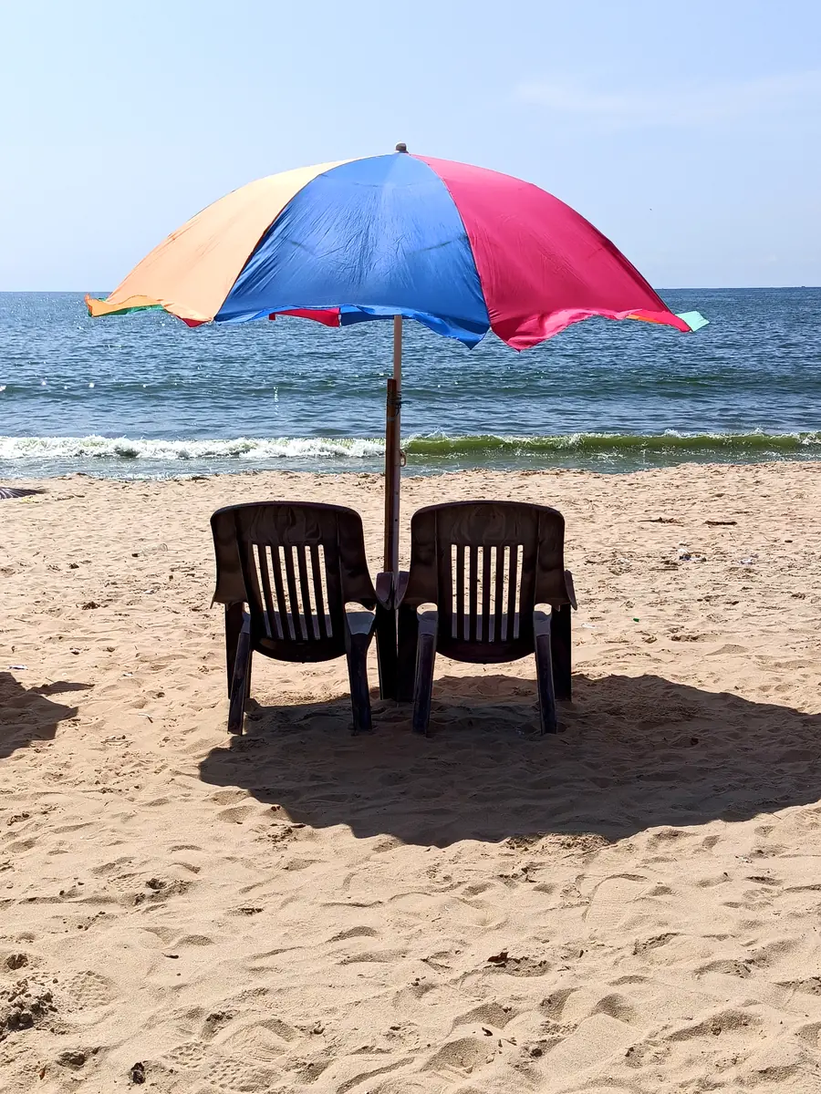Ombrellone colorato e due sedie sulla spiaggia