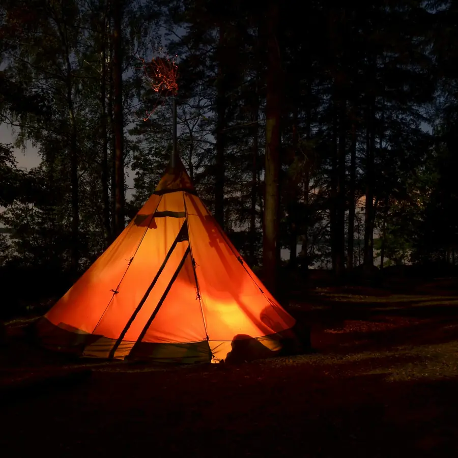 Tenda illuminata di notte nel bosco